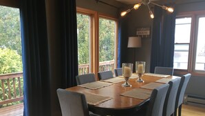 A dining area with a wooden table, eight chairs, and two candle holders.