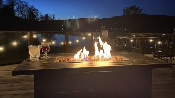 A deck with a fire feature, outdoor seating, and a view of the landscape.