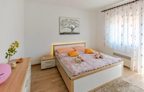 A bedroom with a bed, nightstand, and a wall-mounted painting. - Gorgeous apartment in Pula with WiFi (Pula)