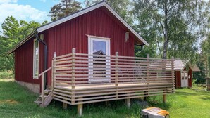 A red wooden cabin with a wooden deck and a small porch. - Cozy home in Sollebrunn with sauna (Sollebrunn)