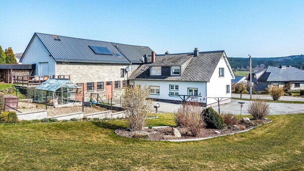 A two-story house with a sloped roof, a visible chimney, and a solar panel on the roof. - 2 bedroom awesome home in Burg-Reuland (Burg-Reuland)