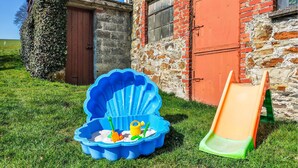 A blue kiddie pool with toys and a slide in front of a rustic building. - 2 bedroom awesome home in Burg-Reuland (Burg-Reuland)