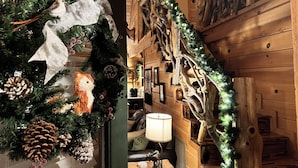 A cozy cabin interior with a Christmas tree, wooden walls, and a rustic decor. - Wildlife Cabin - By Magic Springs, Off-Road Park (Hot Springs)