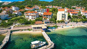 A coastal town with buildings, a beach, and a boat docked at the pier. - Cozy apartment in Barbat na Rabu with WiFi (Barbat na Rabu)