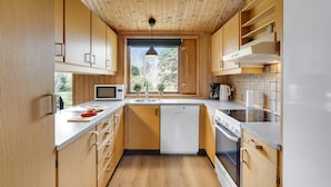 A modern kitchen with wooden cabinets, a microwave, a dishwasher, and a stove. - Awesome home in Væggerløse with kitchen (Væggerløse)