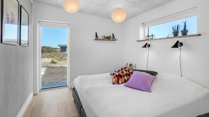 Una camera da letto con un letto, una finestra, una porta e vista sull'esterno.