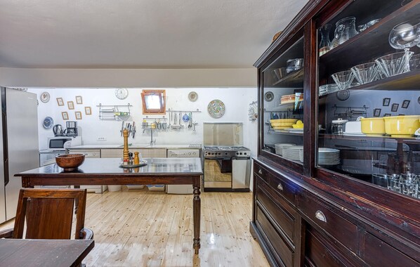 A kitchen with wooden cabinets, a stove, and various kitchen utensils.