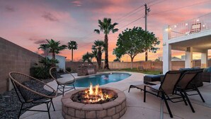 A backyard with a swimming pool, a fire pit, and outdoor seating. - 5BR/3BA NEW Game Room, Pool + Arcade + Fire Pit! (Henderson)