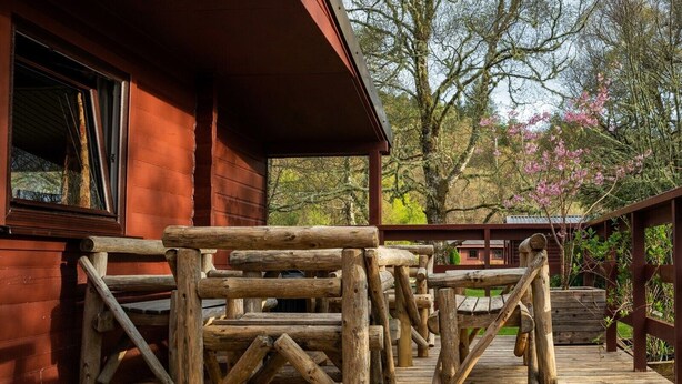 A wooden deck with benches in front of a rustic building.