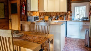 A compact kitchen with white cabinets, a microwave, and a sink.