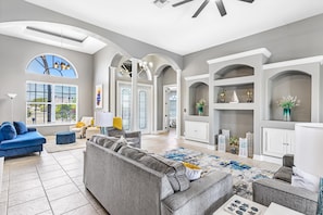 Relax in this stylish living area with a sofa, armchairs, and a view of the outside.