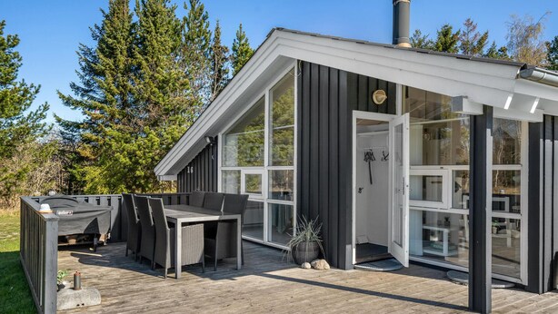 A modern house with a deck, large windows, and outdoor furniture. - 4 bedroom beautiful home in Jerup (Jerup)