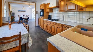 Une cuisine avec des meubles de rangement en bois, un plan de travail et un évier.