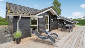 A modern house with a dark exterior, a tiled roof, and a wooden deck. - Beautiful home in Sydals with WiFi (Sydals)