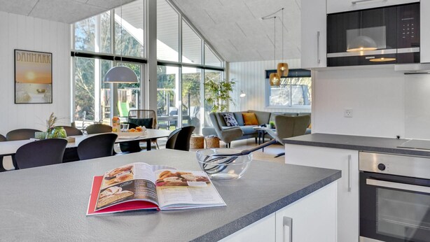 Una cocina moderna con una isla grande, una zona de comedor con vistas y un horno Siemens.