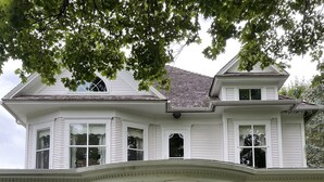 Une maison à deux étages avec un porche à l’avant, une boîte aux lettres et le numéro « 10216 » sur la porte.