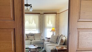 Un salon comprenant un canapé, des fauteuils, une table basse et une lampe.