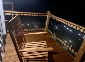 A wooden deck with a bench and a railing.