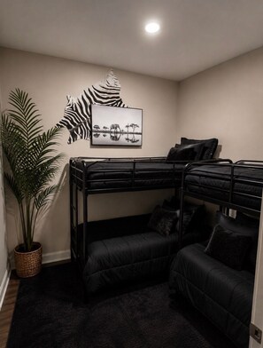 A bunk bed room with a large potted plant, a framed picture on the wall, and a dark rug. - 50-Acre Mountain Retreat: River, Ponds, Trails, Theater & Game Room! Sleeps 14+ (Hendersonville)