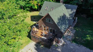 Eine Vogelperspektive eines Holzhauses mit Terrasse, großen Fenstern und Schornstein.