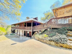 A two-story wooden house with a balcony and a satellite dish.