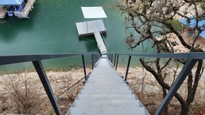 Een metalen trap die naar een steiger leidt, boven een wateroppervlak.