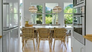 A modern kitchen with a dining area, large windows, and a built-in oven. - 4 bedroom lovely home in Gilleleje (Gilleleje)