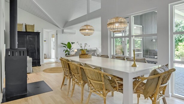 A spacious kitchen with a large island, wicker chairs, and pendant lights. - 4 bedroom lovely home in Gilleleje (Gilleleje)