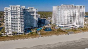 A high-rise hotel with multiple floors, a pool area, and a beach view. - Oceanfront 3 Bedroom/2Bath SeaWatch Resort (Myrtle Beach)