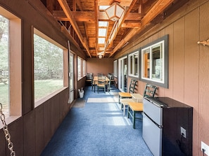 A corridor with wooden walls, large windows, and a blue carpet.