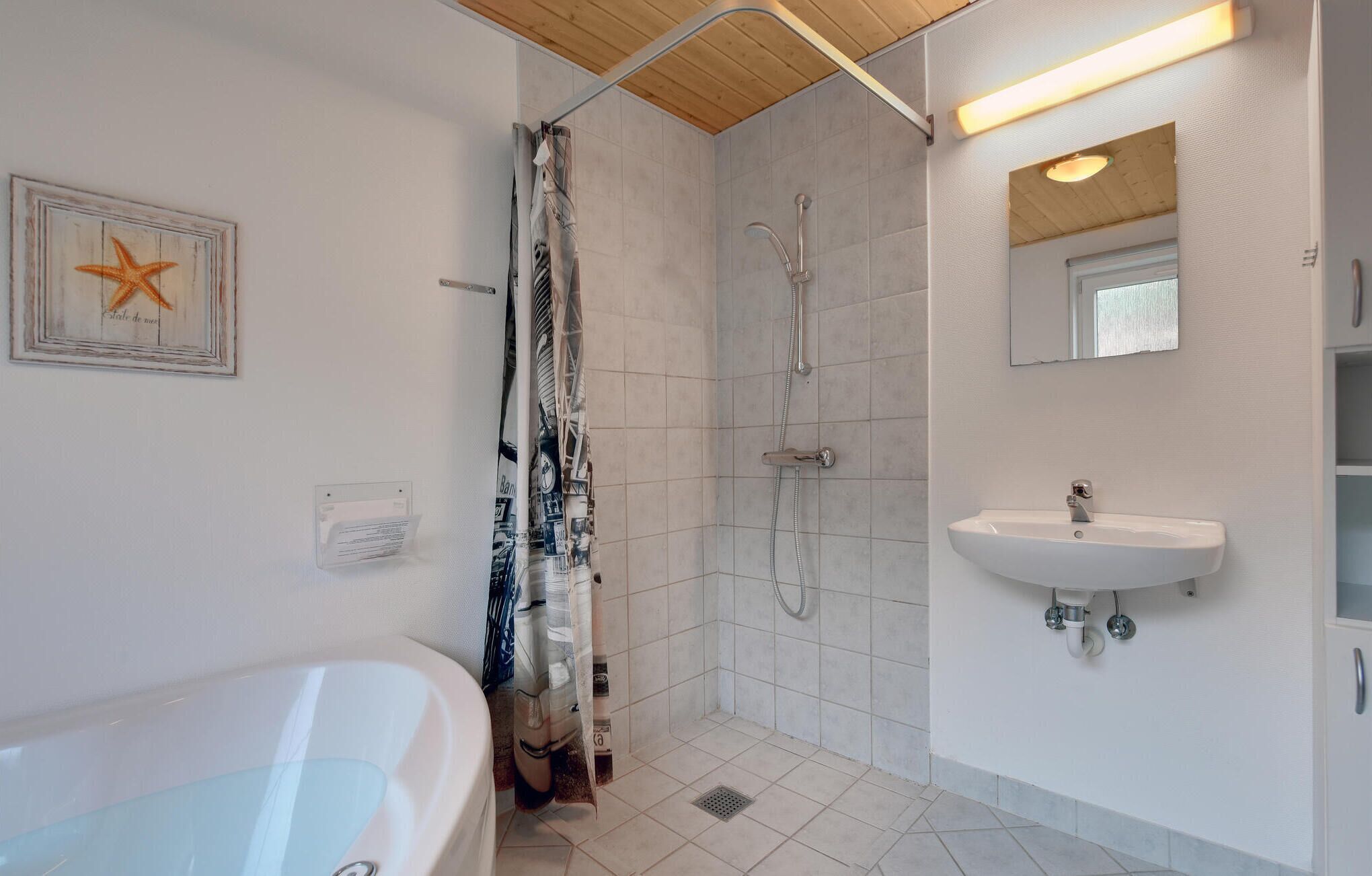 A bathroom with a bathtub, shower, and sink.
