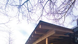 Une cabane en rondins avec une véranda en bois, une table de pique-nique et une pancarte indiquant « Price Bunkhouse ».