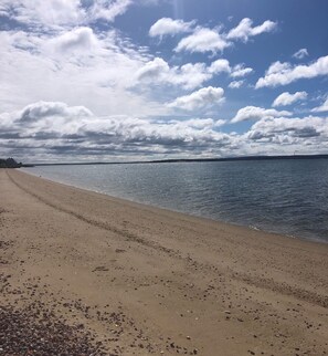 Ranta lähistöllä, aurinkotuoleja, rantapyyhkeitä