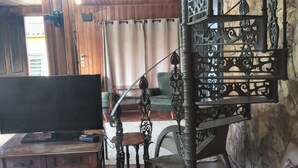 Un intérieur en bois avec un escalier, un téléviseur et un canapé.