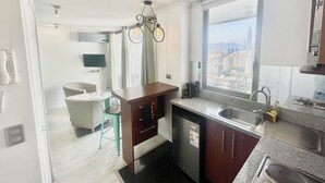 Una cocina moderna con lavavajillas integrado, ventana con vista a la ciudad y comedor con silla y mesa.