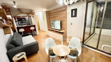Apartamento Deluxe | Zona de estar | Televisión de pantalla plana de 42 pulgadas con canales por cable