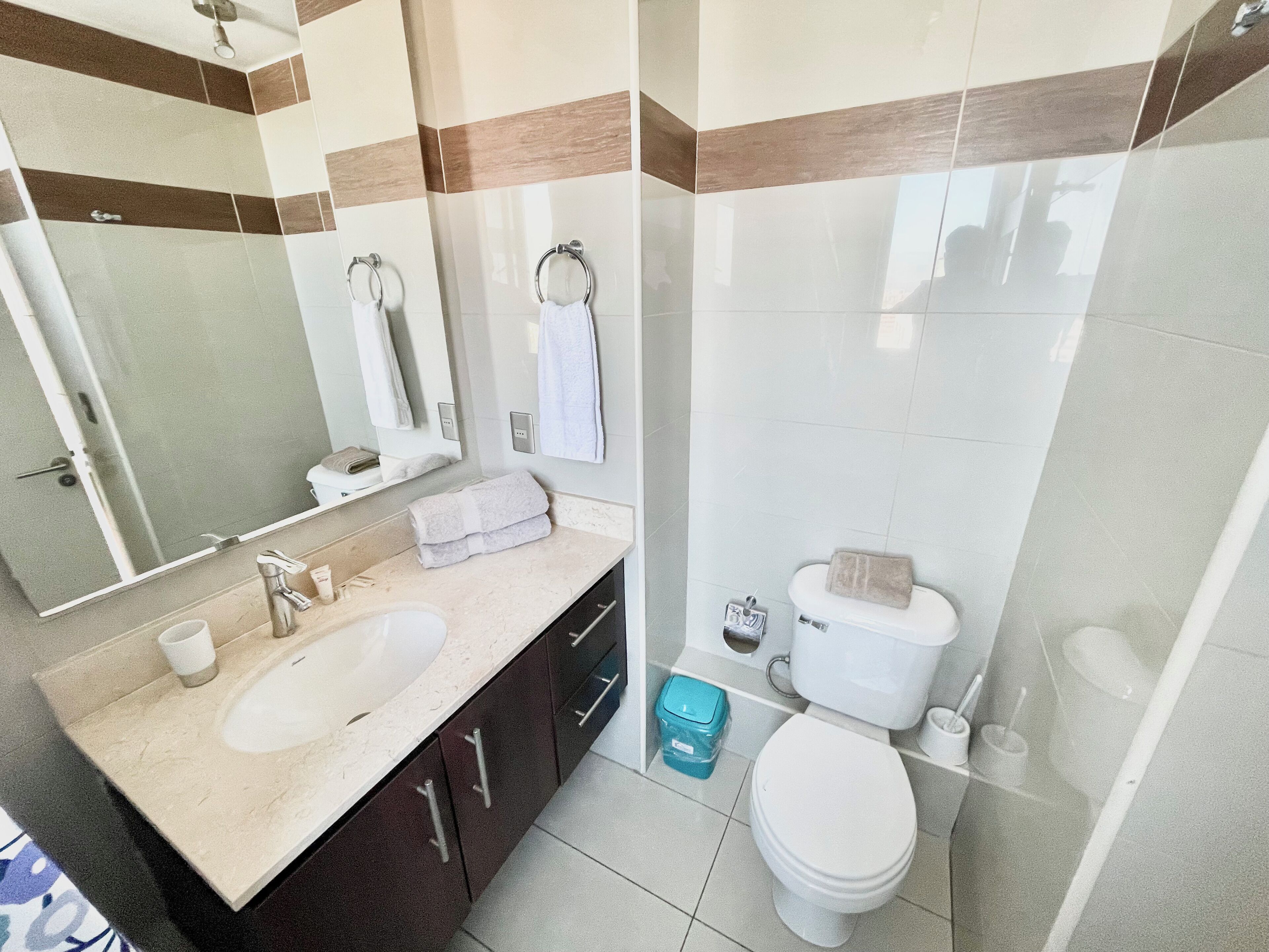 Un baño moderno con lavamanos doble, inodoro y zona de ducha.