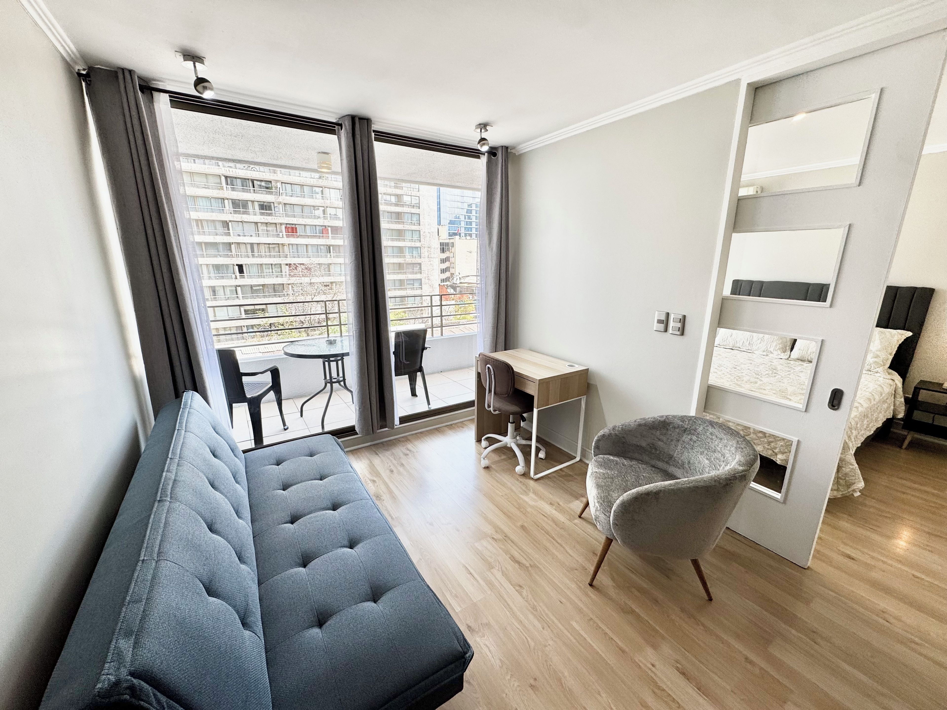 Une chambre moderne comprenant un lit, un bureau et un coin salon.