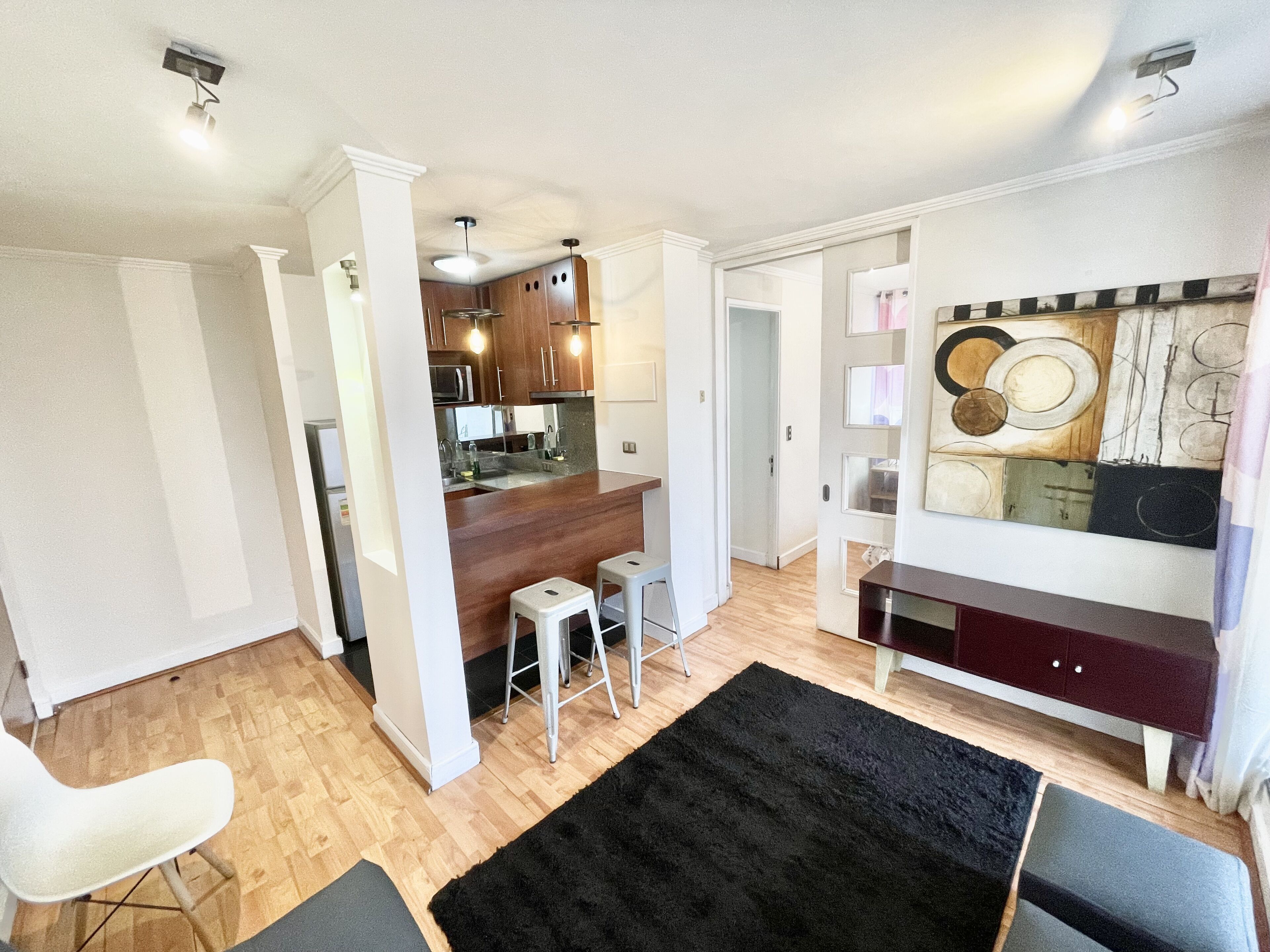A modern apartment with a kitchen, dining area, and living room.