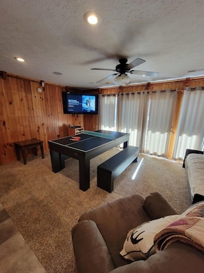Ein Zimmer mit Billardtisch, Deckenventilator, Fernseher und Bett.
