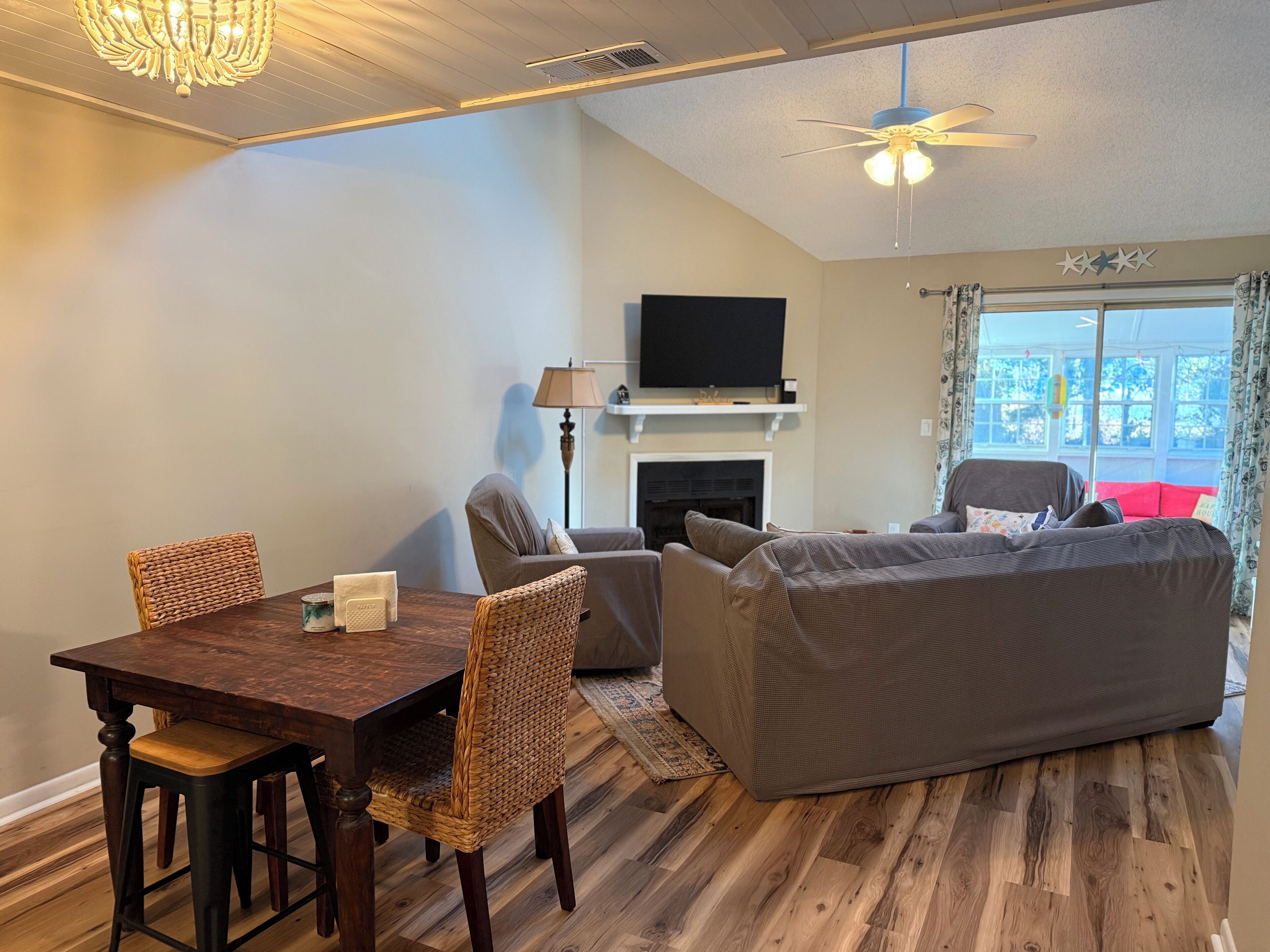 A cozy room with a dining table, chairs, a sofa, a bed, a TV, and a fireplace.