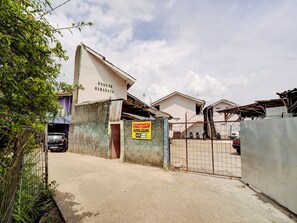 Un complexe résidentiel fermé, avec une pancarte indiquant « Pondok Sabaraya » et une autre annonçant un accès « Wi-Fi gratuit ».