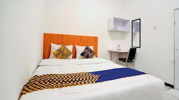 Una habitación de hotel con una cama, un escritorio y una silla.