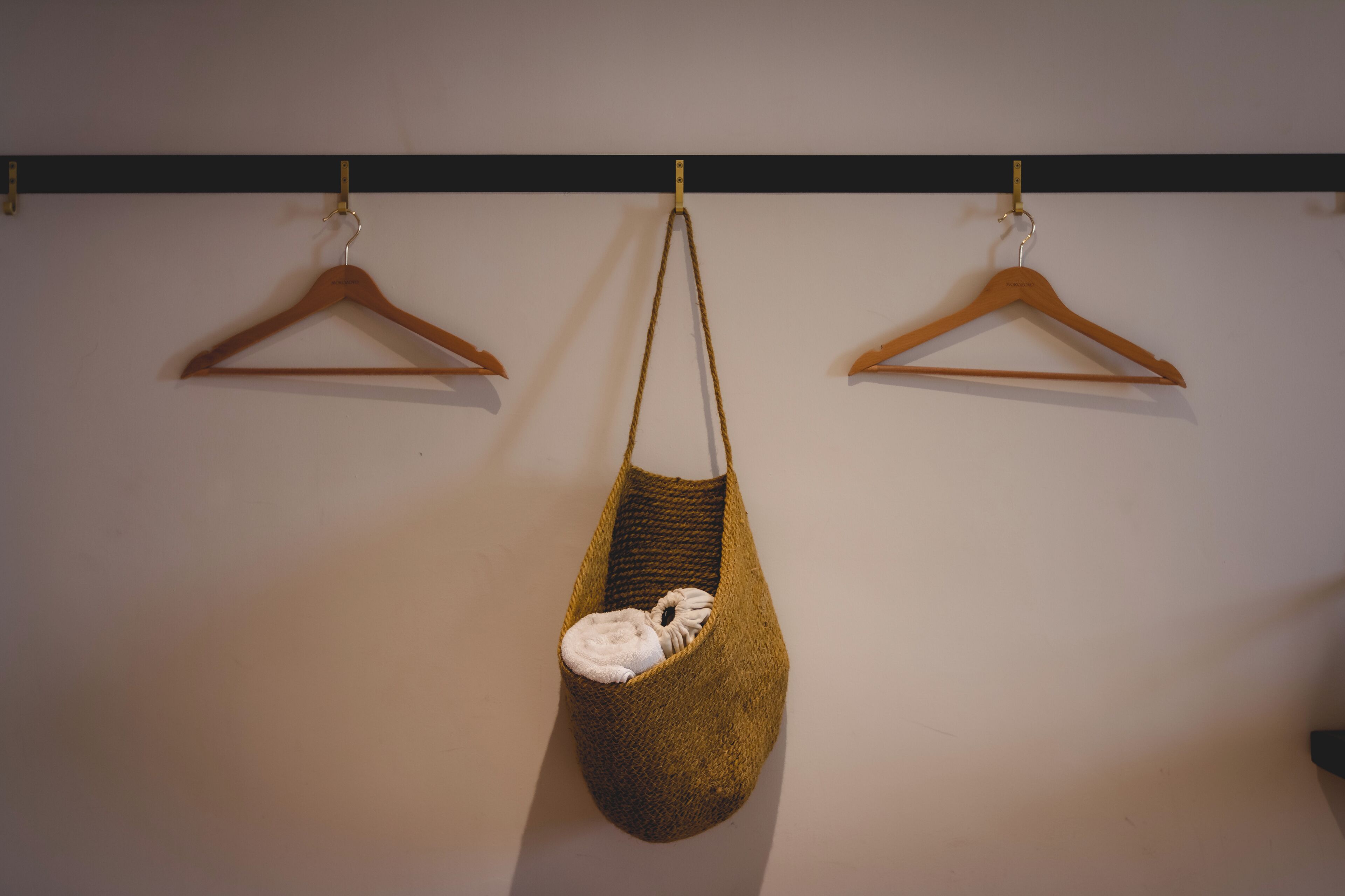 A room with a hanging chair and two wooden hangers on the wall.