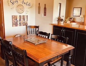 A dining area with a wooden table, chairs, and a glass tray. - Limestone Corner Bungalow (Graytown)