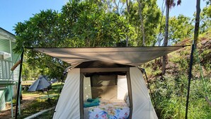 A tent with a sleeping area, a canopy, and a patterned mat. - Meyenburg Luxury Tent with shared bathroom/kitchen/lounge (Mount Morgan)