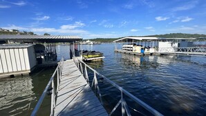 A dock with a boat and a covered area with a roof. - Lake front with orovate dock located in same cove as Coconuts!!! (Gravois Mills)