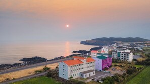 Une ville côtière avec des bâtiments situés près de la mer, une route et un ciel dégagé.