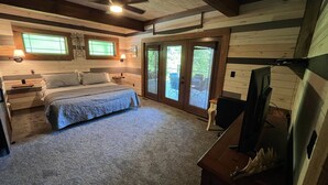 Ein Schlafzimmer mit Bett, Schreibtisch, Stuhl, Deckenventilator und Fenster.