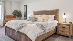 Une chambre à coucher avec un lit en bois, une table de chevet avec une lampe et une chaise.